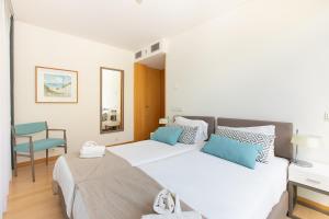a bedroom with two beds and a desk and a chair at VILLA FARHAT in Troia