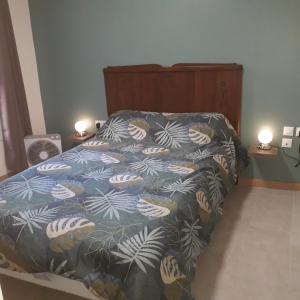 une chambre avec un lit avec une couette bleue et blanche dans l'établissement Chez René, à Montagnac