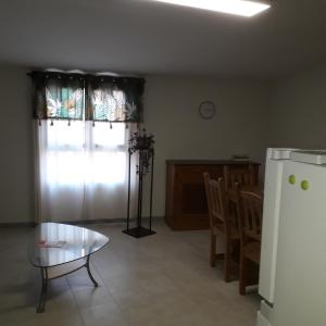 un salon avec une table et un réfrigérateur dans l'établissement Chez René, à Montagnac