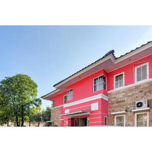 a red building with a tree in front of it at Surya Inn Syariah Cikarang RedPartner in Bekasi