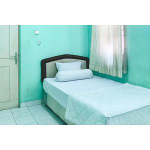 a bedroom with two beds in a blue room at Surya Inn Syariah Cikarang RedPartner in Bekasi