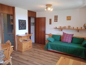 a living room with a green couch and a table at Mountain Shelter in Passo del Tonale