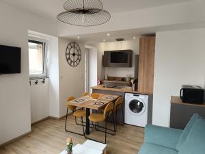 eine Küche und ein Wohnzimmer mit Tisch und Stühlen in der Unterkunft aux nids douillets mayetois "les tourtereaux" in Mayet-de-Montagne + 5 Fotos