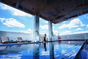 a woman standing in front of a swimming pool at Patra Malioboro Hotel in Yogyakarta