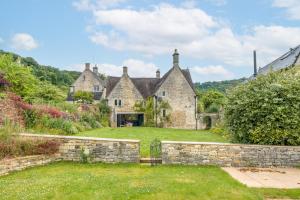 an old stone house with a garden in the foreground at The Mill House - Beautiful 4BD Family Home! in Harescombe