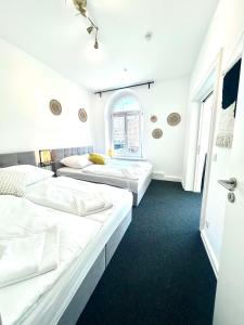 a room with three beds and a window at Central Apartment for up to 10 Guests in Hamburg