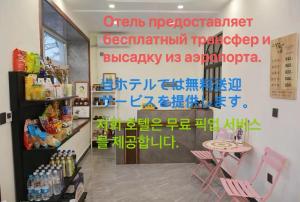 un negozio con scritte sul muro e un tavolo con sedie di Harbin Qiju Hotel Taiping International Airport a Wujia