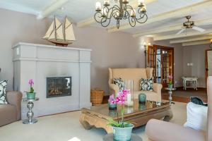 a living room with a table and a fireplace at Franschhoek Manor Luxury Boutique Guesthouse in Franschhoek
