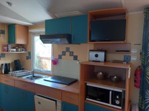 Kuchyň nebo kuchyňský kout v ubytování Mobil Home climatisé avec terrasse dans camping l'Escale, calme, à 20 mn à pied de la plage