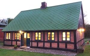 una casa con techo verde y luces encendidas en Villa Zira en Bjerringbro