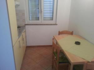 a small kitchen with a table and a window at Apartmaji paliska a in Izola