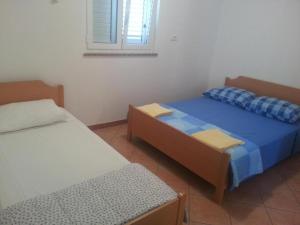 a room with two beds and a window at Apartmaji paliska a in Izola