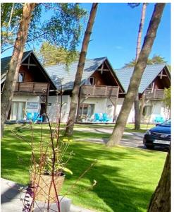 una casa con delle palme davanti di Domki Poezja Ciszy a Dębki