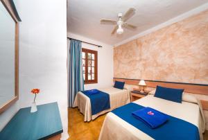 a room with two beds and a ceiling fan at Comitas Tramontana Park in Fornells +28 photos