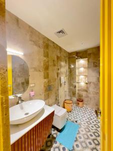 a bathroom with a sink and a toilet and a mirror at Hotel Grand Kailash Haveli in Kotdwāra