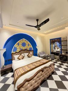 a bedroom with a large bed with a blue headboard at Hotel Grand Kailash Haveli in Kotdwāra