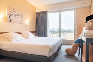 Rúm í herbergi á Brit Hotel Le Parc Vichy