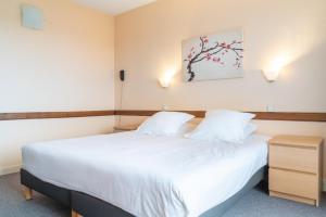 Rúm í herbergi á Brit Hotel Le Parc Vichy