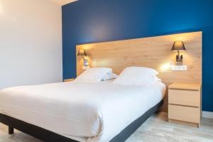Rúm í herbergi á Brit Hotel Le Parc Vichy
