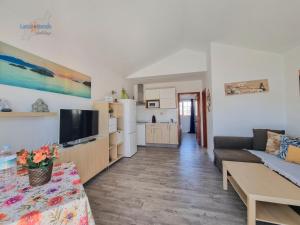 ein Wohnzimmer mit Couch und Fernseher in der Unterkunft Vivienda Vacacional Casa Mar y Volcan Vista mar Piscina Playa 5 min Wifi in Puerto del Carmen