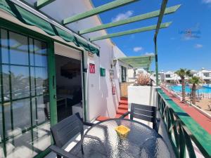 einen Tisch auf dem Balkon mit Blick auf den Strand in der Unterkunft Vivienda Vacacional Casa Mar y Volcan Vista mar Piscina Playa 5 min Wifi in Puerto del Carmen