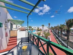 einen Balkon mit einem Tisch und Poolblick in der Unterkunft Vivienda Vacacional Casa Mar y Volcan Vista mar Piscina Playa 5 min Wifi in Puerto del Carmen + 18 Fotos