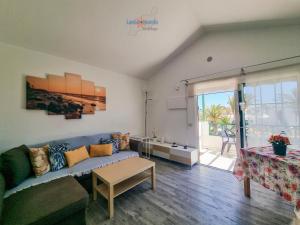 ein Wohnzimmer mit einer Couch und einem Tisch in der Unterkunft Vivienda Vacacional Casa Mar y Volcan Vista mar Piscina Playa 5 min Wifi in Puerto del Carmen