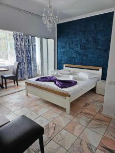 una camera da letto con un letto grande con una coperta viola di Casa Mary a Eforie Nord