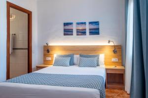 a bedroom with a large bed with blue pillows at Comitas Tramontana Park in Fornells