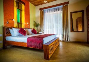 a bedroom with a large bed with a window at Galavilla Boutique Hotel & Spa in Kandy