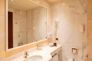 łazienka z umywalką i dużym lustrem w obiekcie Hotel Internazionale w Bolonii +16 zdjęć