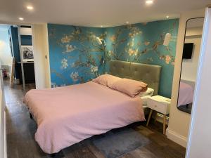 a bedroom with a pink bed and a blue wall at Number 1 in Sudbury