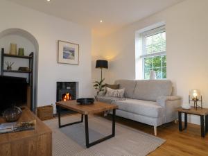 un salon avec un canapé et une cheminée dans l'établissement Lavender Cottage, à Bourne