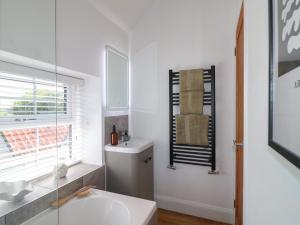 une salle de bain blanche avec un lavabo et un miroir dans l'établissement Lavender Cottage, à Bourne 28 autres photos
