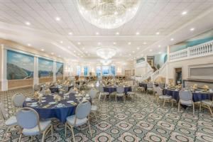 a banquet hall with tables and chairs and a chandelier at Ramada by Wyndham Hammond Hotel & Conference Center in Hammond