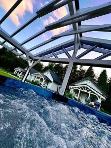 eine Brücke über einen Wasserkörper mit Häusern in der Unterkunft CICHAta Nad Zatoką in Cammin in Pommern