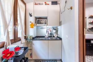 une petite cuisine avec un évier et un réfrigérateur dans l'établissement Two Steps From-Duomo Design One Room Flat, à Milan