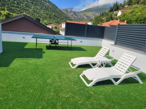 two chairs and a ping pong table on a lawn at Herzegovina Dream Residence in Stolac