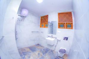 a white bathroom with a sink and a toilet at Ama Airport Hotels in Seeduwa