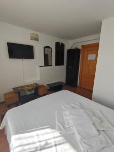 une chambre avec un lit blanc et une télévision à écran plat dans l'établissement Camere de inchiriat EDELWEISS, à Dumbrava Roşie 19 autres photos