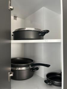 dos ollas y sartenes en estanterías en una cocina en Villa Badem Çiçeği, en Ayvacık
