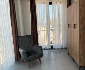 una silla en una habitación con una ventana grande en Villa Badem Çiçeği, en Ayvacık