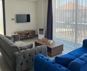 Una sala de estar con dos sofás y un televisor. en Villa Badem Çiçeği, en Ayvacık