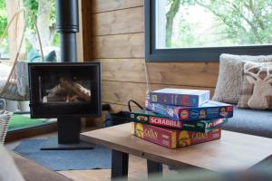 a stack of books sitting on a table next to a fireplace at Casa rural Los Pilares de la Sierra in Arahuetes