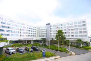 a large white building with cars parked in a parking lot at Park Inn By Radisson Clark in Angeles