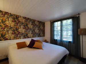 a bedroom with a large white bed and a window at LES "AGATHINES" Maison 4 chambres, de 1 à 9 personnes, deux logements indépendants in Ronce-les-Bains