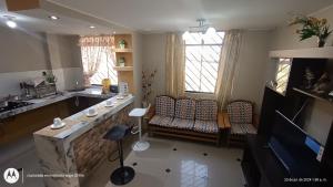 a living room with a couch and a table and windows at LUANA’S HOUSE in Ica