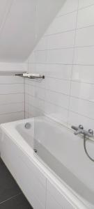 bañera blanca con pared de cristal en Sparrenburg Oisterwijk, 4 persoons Bungalow, en Oisterwijk
