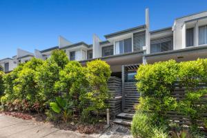 ein Mehrfamilienhaus mit Bäumen davor in der Unterkunft Bula Holiday Villa in Casuarina