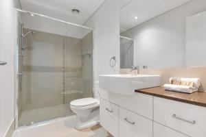 ein Badezimmer mit Dusche, Toilette und Waschbecken in der Unterkunft Bula Holiday Villa in Casuarina